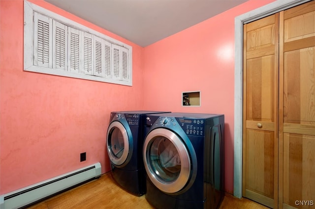 washroom featuring light wood-type flooring, baseboard heating, and separate washer and dryer