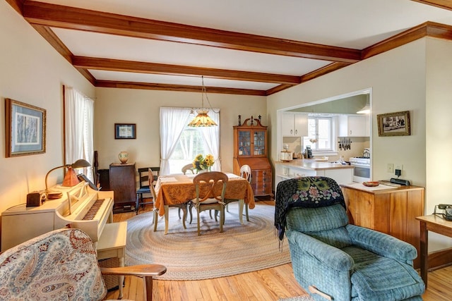 dining area featuring beam ceiling and light hardwood / wood-style floors