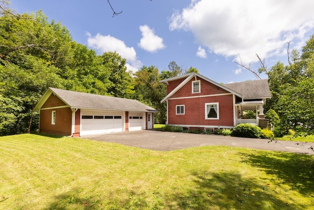 view of front of property with an outdoor structure, a garage, and a front lawn