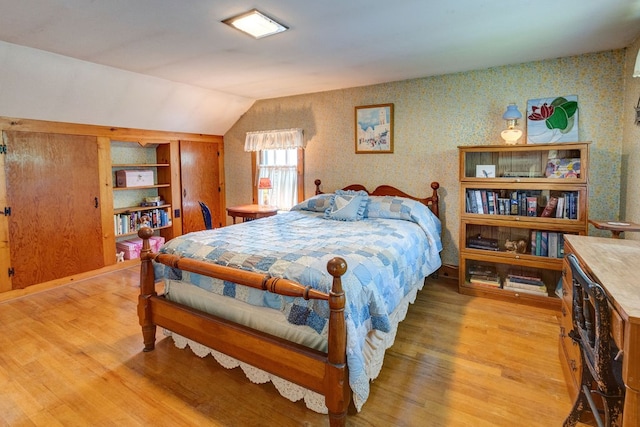 bedroom with vaulted ceiling and wood-type flooring