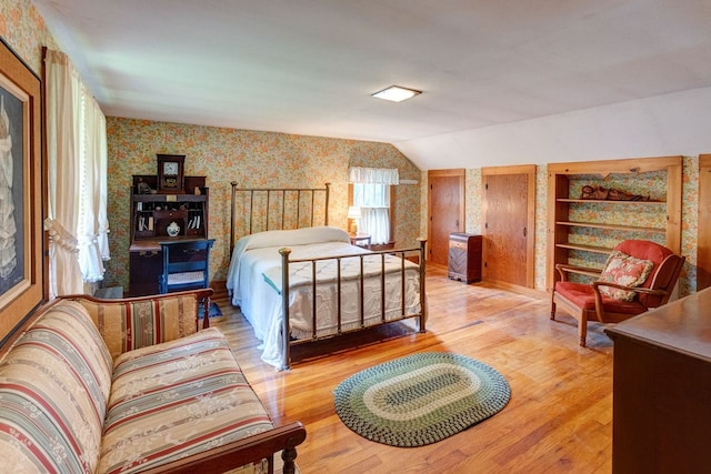 bedroom with light hardwood / wood-style floors and lofted ceiling