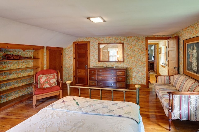 bedroom featuring hardwood / wood-style floors and lofted ceiling