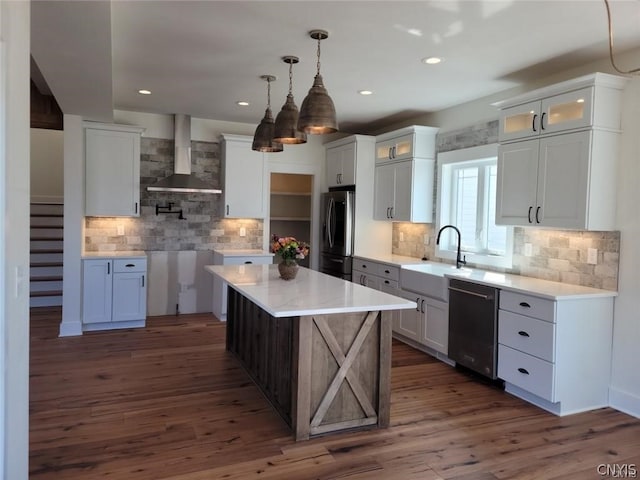 kitchen featuring wall chimney range hood, dark hardwood / wood-style flooring, tasteful backsplash, a center island, and stainless steel appliances