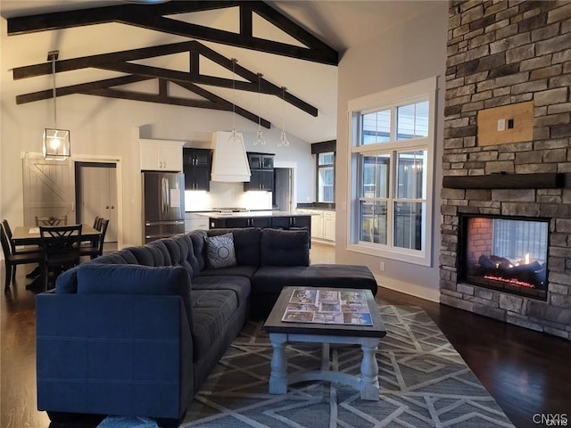 living room featuring beam ceiling, dark hardwood / wood-style flooring, high vaulted ceiling, and a stone fireplace