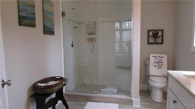 bathroom with toilet, a shower with shower door, and vanity