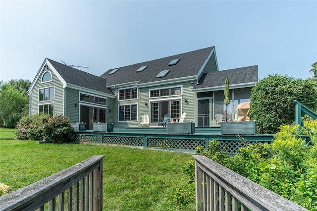 27454 County Route 57, Lyme, NY 13693 - back of house with a shingled roof, a sunroom, a lawn, and a deck