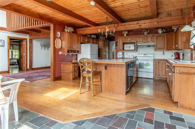 27454 County Route 57, Lyme, NY 13693 - kitchen featuring white appliances, a sink, under cabinet range hood, wooden ceiling with exposed beams, and light countertops