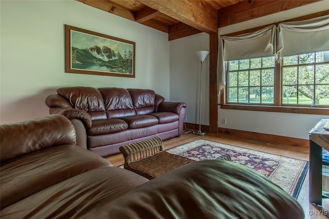 living room featuring beam ceiling, wooden ceiling, and light hardwood / wood-style flooring