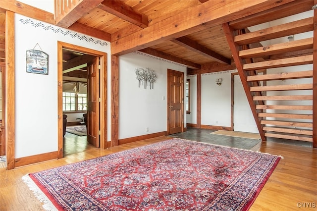 empty room featuring light hardwood / wood-style floors, wood ceiling, and beamed ceiling