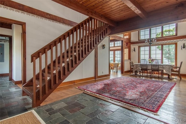 27454 County Route 57, Lyme, NY 13693 - stairs featuring baseboards, wooden ceiling with exposed beams, stone tile flooring, a chandelier, and electric panel