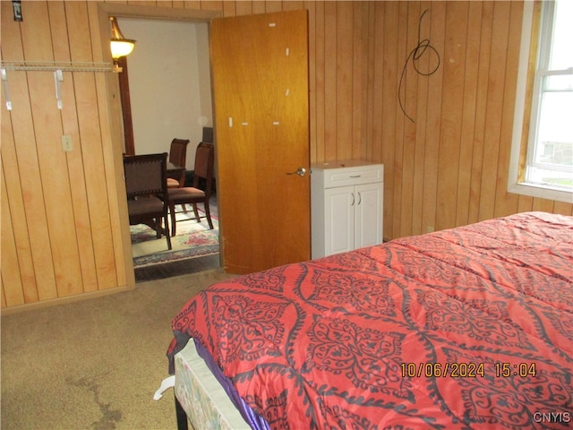 bedroom featuring wooden walls and carpet flooring