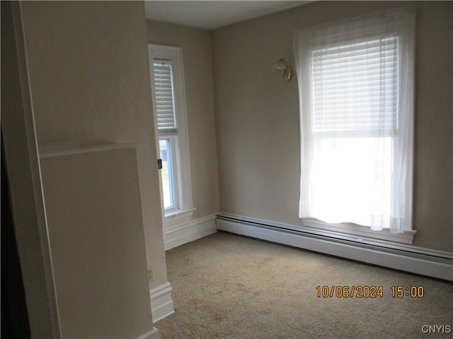 carpeted spare room featuring baseboard heating