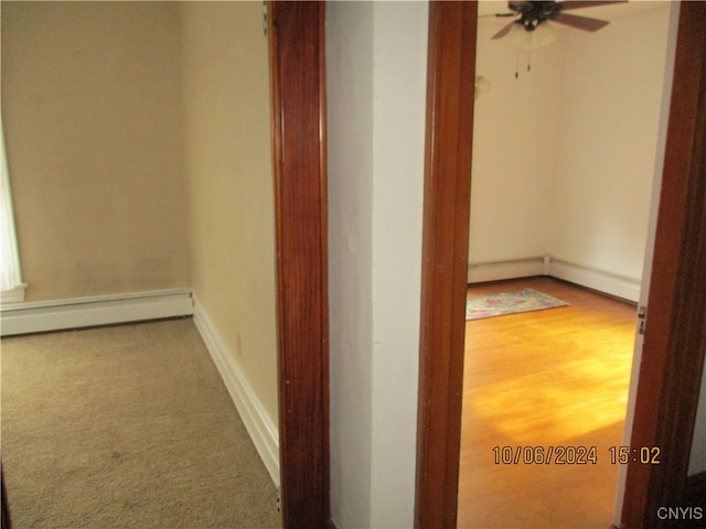 hallway featuring a baseboard radiator and hardwood / wood-style floors