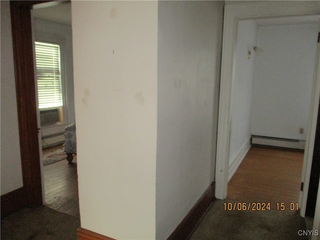 corridor with a baseboard radiator and dark wood-type flooring