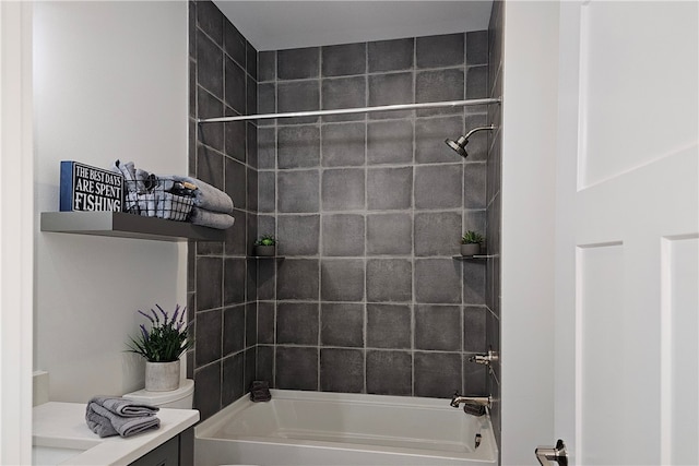 full bathroom featuring tiled shower / bath, vanity, and toilet