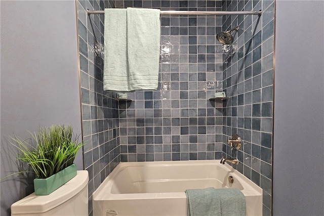 bathroom featuring tiled shower / bath combo and toilet