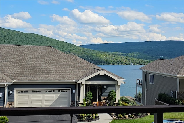 exterior space with a water and mountain view and a garage