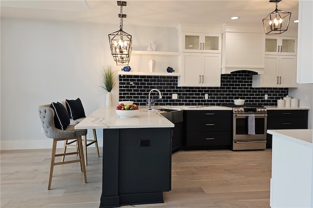 kitchen featuring white cabinets, an inviting chandelier, hanging light fixtures, and stainless steel range oven