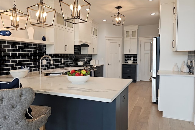 kitchen featuring white cabinets, a notable chandelier, hanging light fixtures, and kitchen peninsula