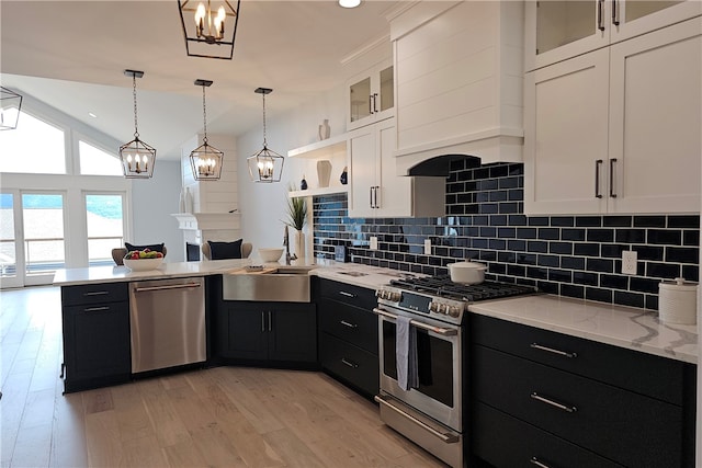 kitchen featuring white cabinets, stainless steel appliances, pendant lighting, and light hardwood / wood-style flooring