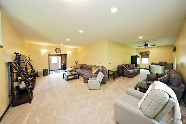 living room featuring ceiling fan, light carpet, and a healthy amount of sunlight