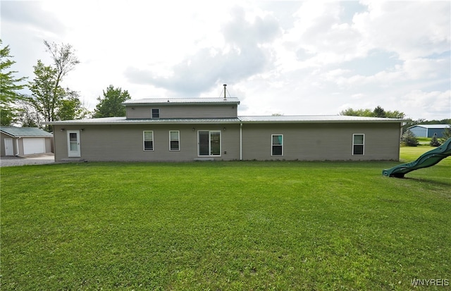 rear view of house with a lawn and a playground