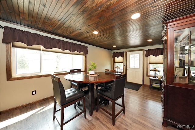 dining area featuring hardwood / wood-style flooring, a healthy amount of sunlight, and wooden ceiling