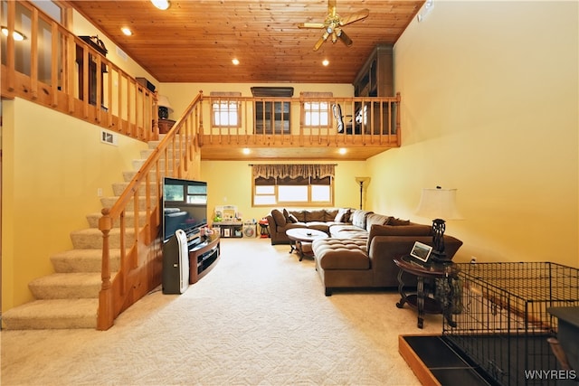 living room featuring a towering ceiling, light carpet, wooden ceiling, and ceiling fan