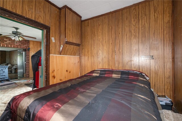 bedroom featuring wooden walls, carpet flooring, and ceiling fan