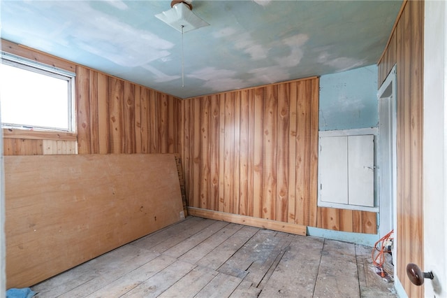 empty room with wooden walls and light hardwood / wood-style flooring