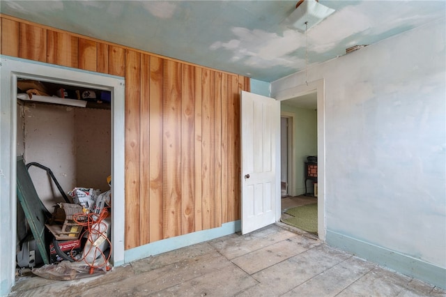 unfurnished bedroom featuring a closet and wooden walls