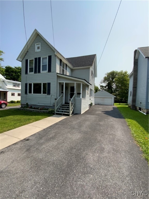 view of front of home with a garage, a front lawn, and an outdoor structure