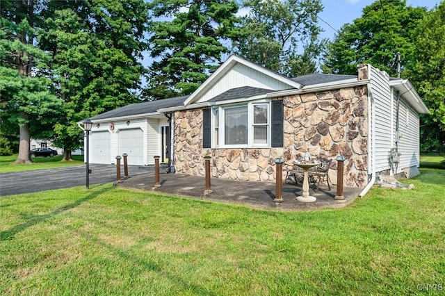 single story home with a garage and a front lawn