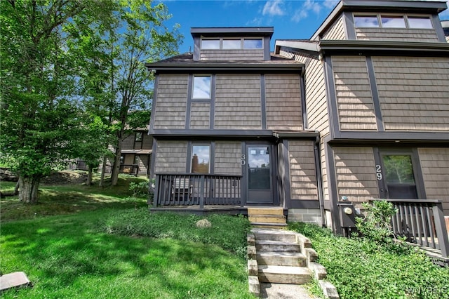 view of front of property featuring a wooden deck and a front lawn