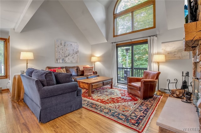 living room with hardwood / wood-style flooring, baseboard heating, and high vaulted ceiling