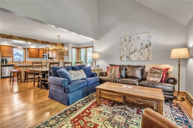 living room with light hardwood / wood-style floors, an inviting chandelier, and a healthy amount of sunlight