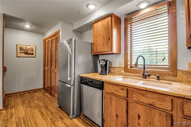 kitchen featuring light hardwood / wood-style floors, a wealth of natural light, sink, and stainless steel appliances