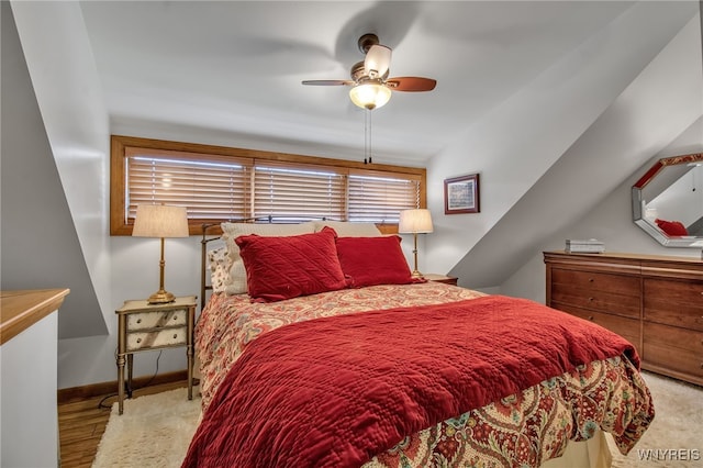 bedroom with ceiling fan, light wood-type flooring, and vaulted ceiling