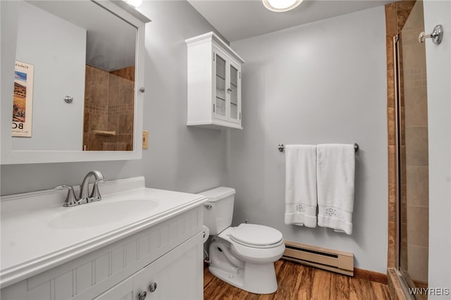 bathroom with hardwood / wood-style flooring, a shower with shower door, a baseboard heating unit, vanity, and toilet