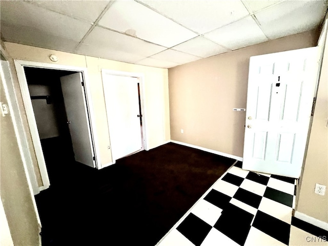 interior space featuring a paneled ceiling and tile patterned flooring