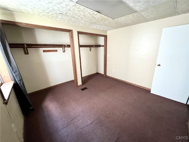 unfurnished bedroom featuring carpet floors and a drop ceiling