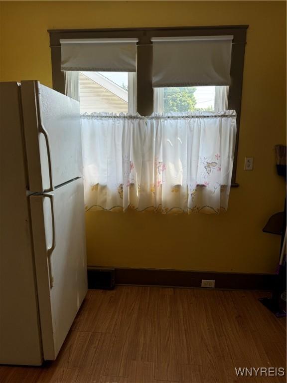 kitchen featuring hardwood / wood-style floors and white fridge