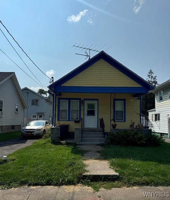 bungalow-style home with a front lawn and a porch