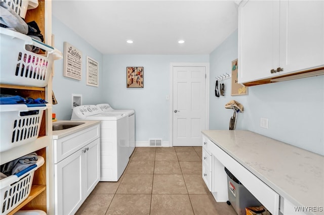 laundry area with cabinets, independent washer and dryer, and light tile patterned flooring