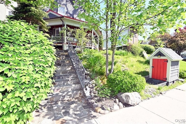 view of yard featuring a storage unit and covered porch