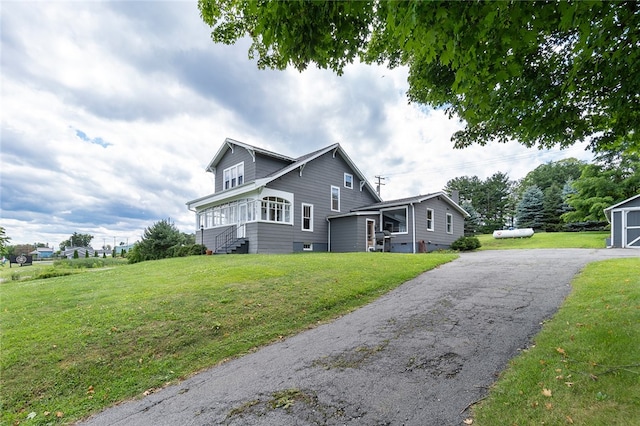 view of front of home featuring a front lawn and an outdoor structure