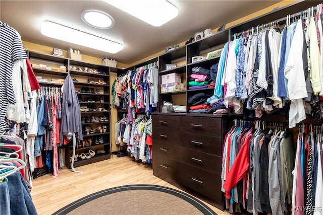 walk in closet with light hardwood / wood-style floors