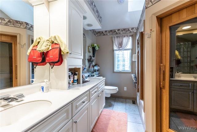 bathroom featuring tile patterned floors, double sink vanity, and toilet