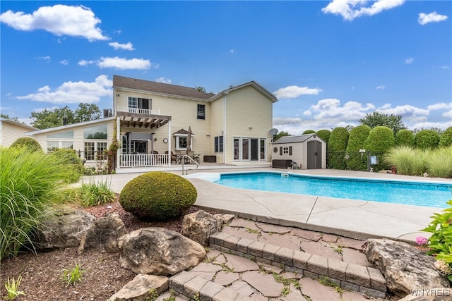 view of swimming pool with a patio and an outbuilding