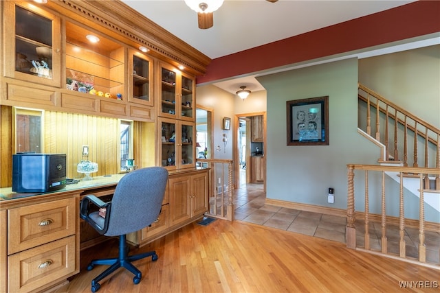 office space featuring ceiling fan, light hardwood / wood-style floors, and built in desk